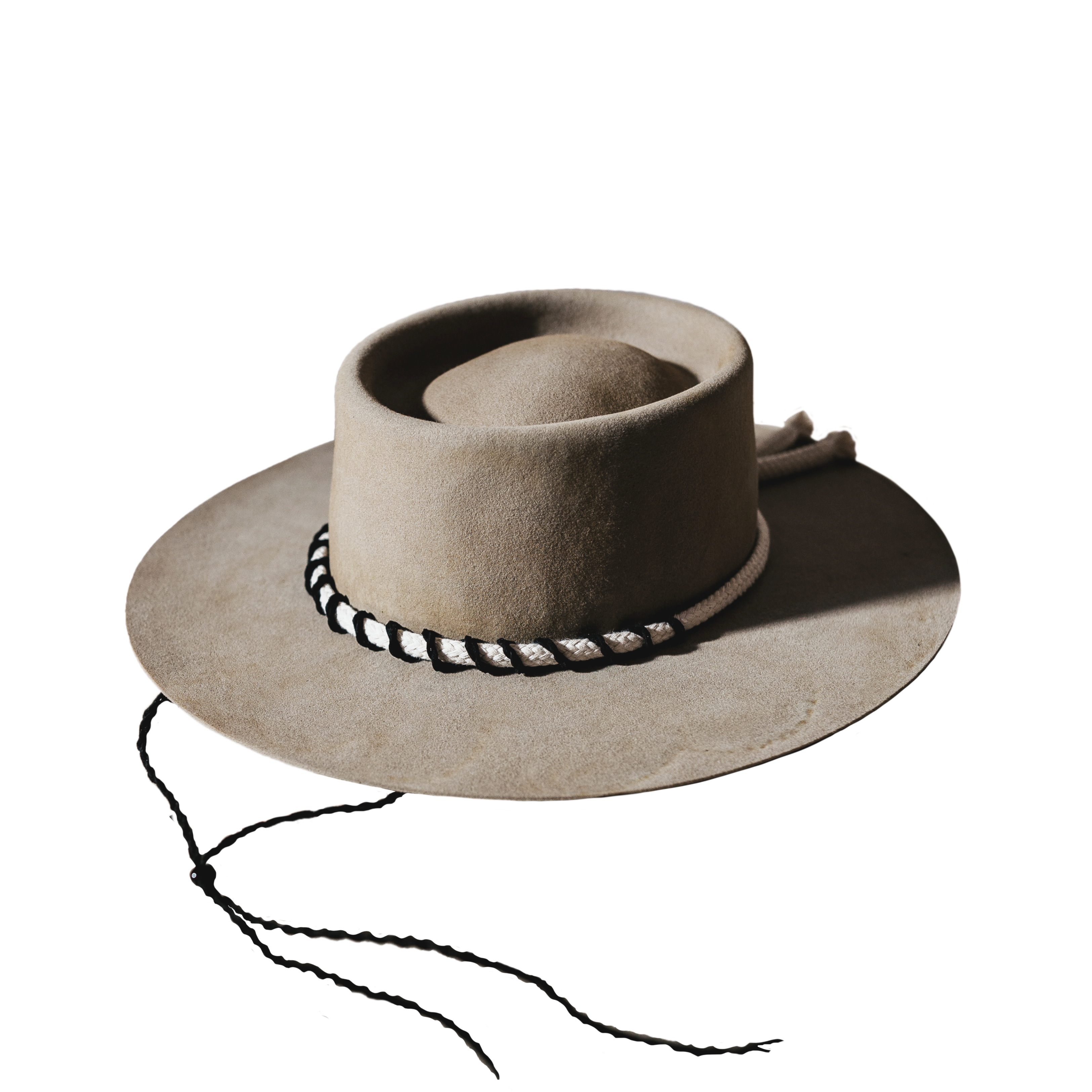 A beautifully handcrafted Crown of the Vagabond hat by the hatters Ruth and Chris on Mallorca with traditional tools in the color Prairie Dust shaped in Oasis with a classy fisherman look inspired by Santorini’s cleanness and the rough sea surrounding it consisting of a white robe surrounded by a corded leather string lead through eyelets down to use it as a chinstrap fixed with a pearl and a flat clean brim - branded with the serial number 24.