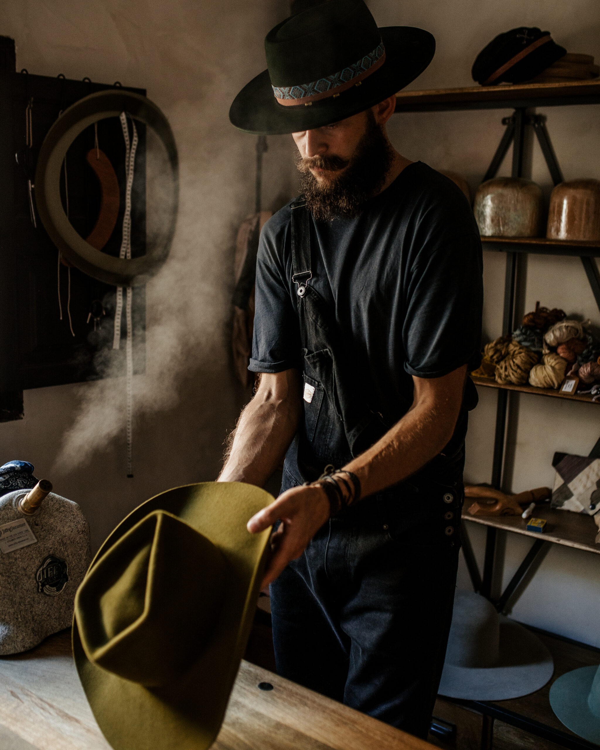 Crown of the Vagabond hatter Chris shaping a new custom ordered hat in guacamole with a lot of steam and perfect light