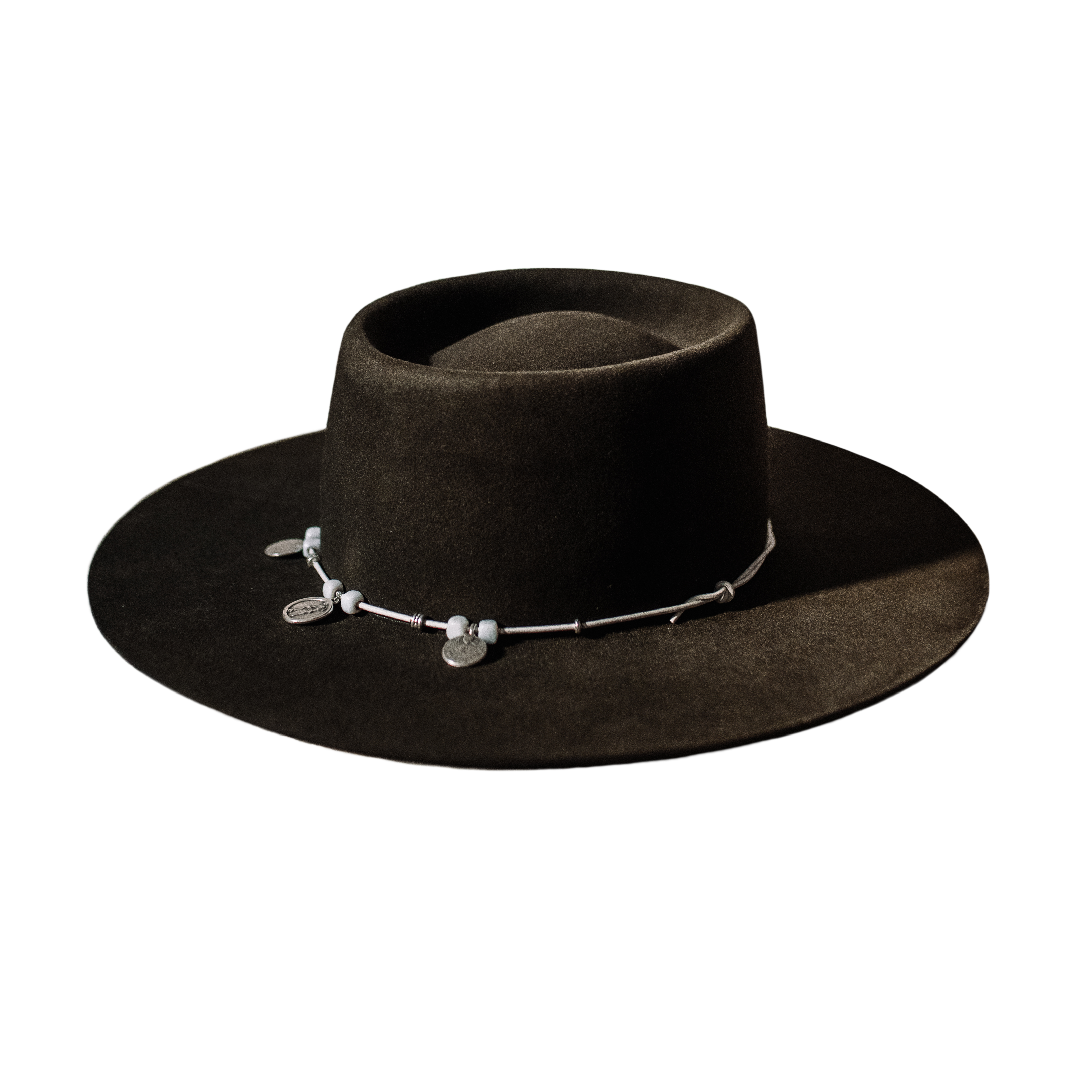 Crown of the Vagabond Hat on Mallorca in color Tortuga Oasis-shaped. Centred silver Coins on a white leather string.