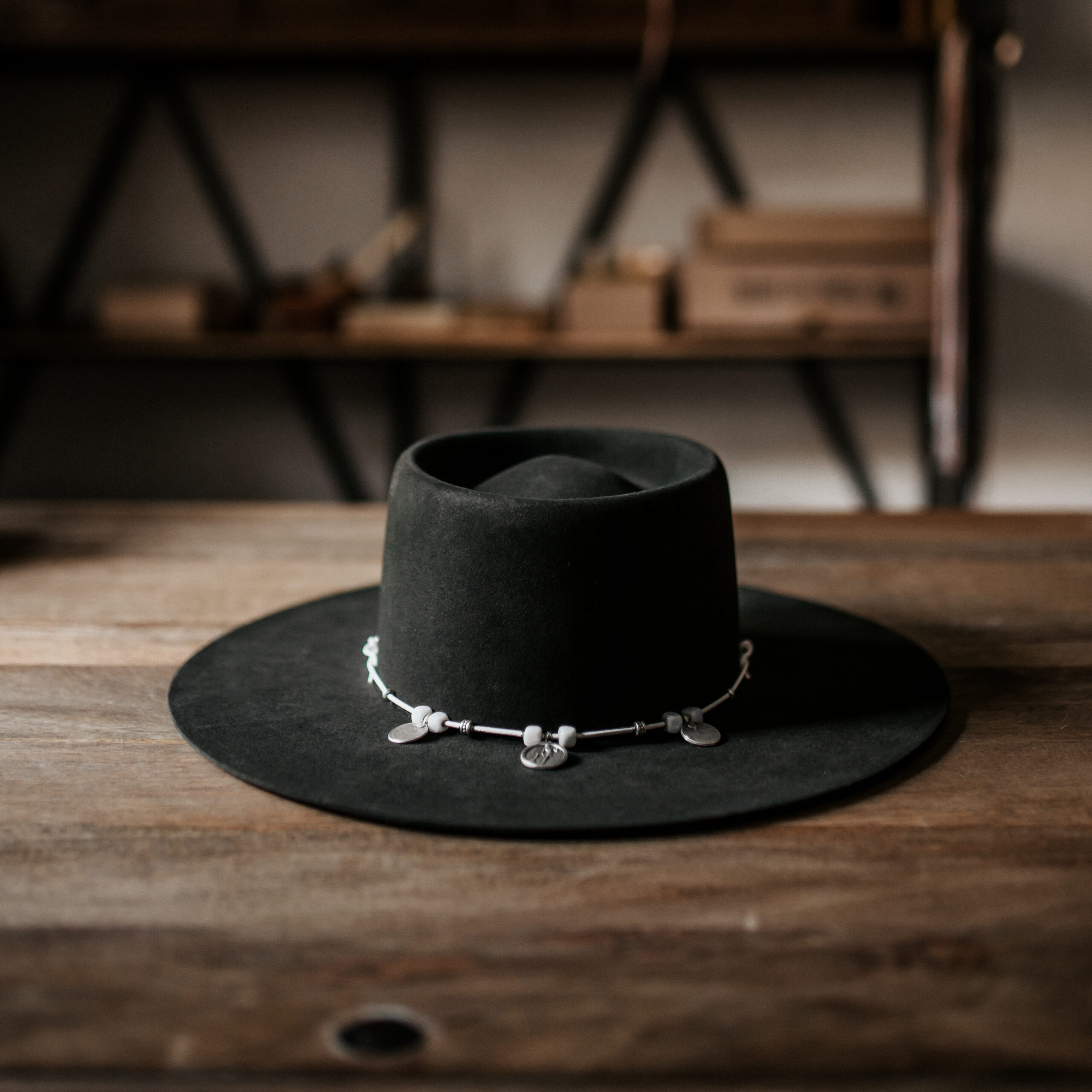 Crown of the Vagabond Hat on Mallorca in color Tortuga Oasis-shaped. Centred silver Coins on a white leather string.