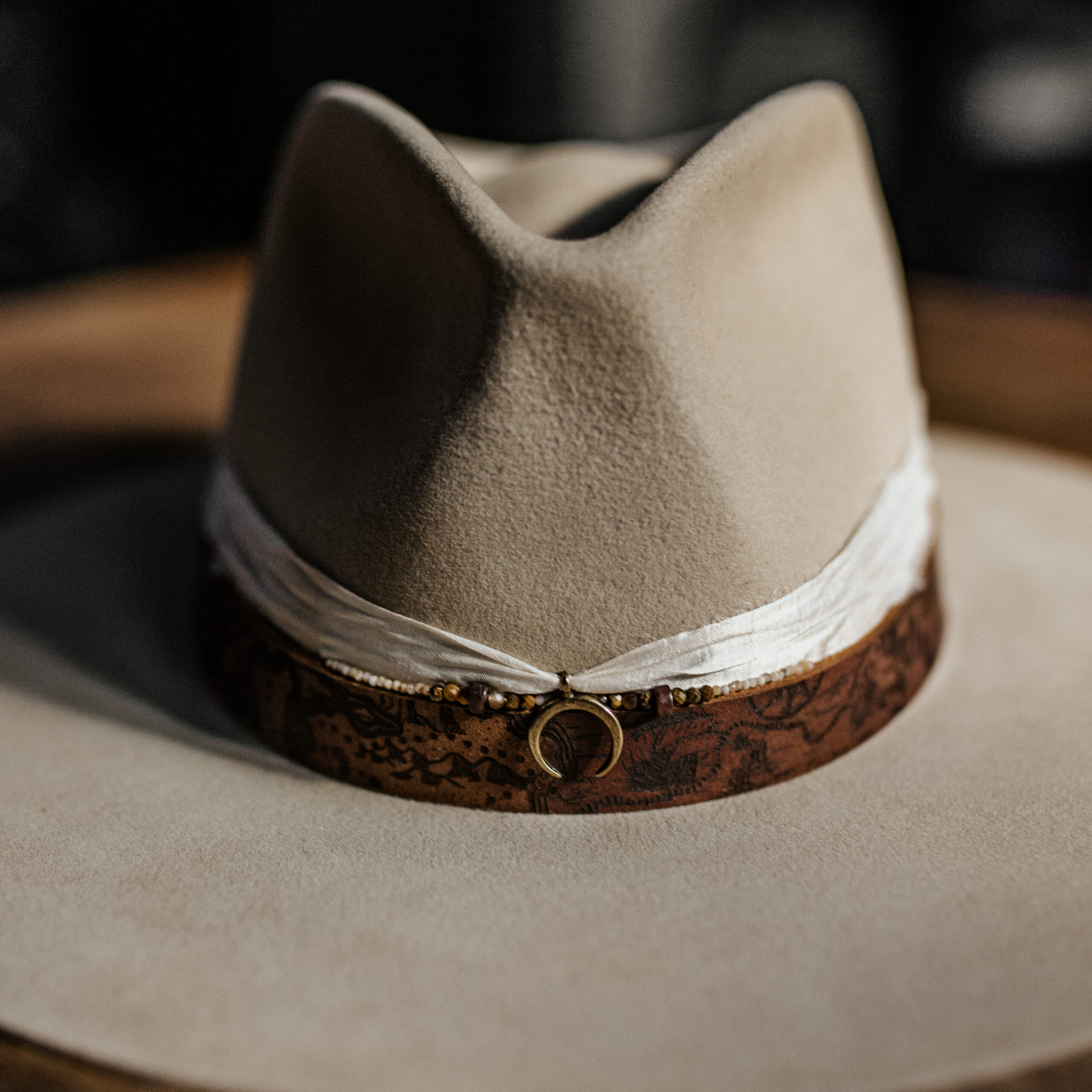Crown of the Vagabond Hat on Mallorca in color Dun Gold-Digger-shaped. Map laserengraved leather strap, ivory sari silk, gemstones and crescent moon charm.