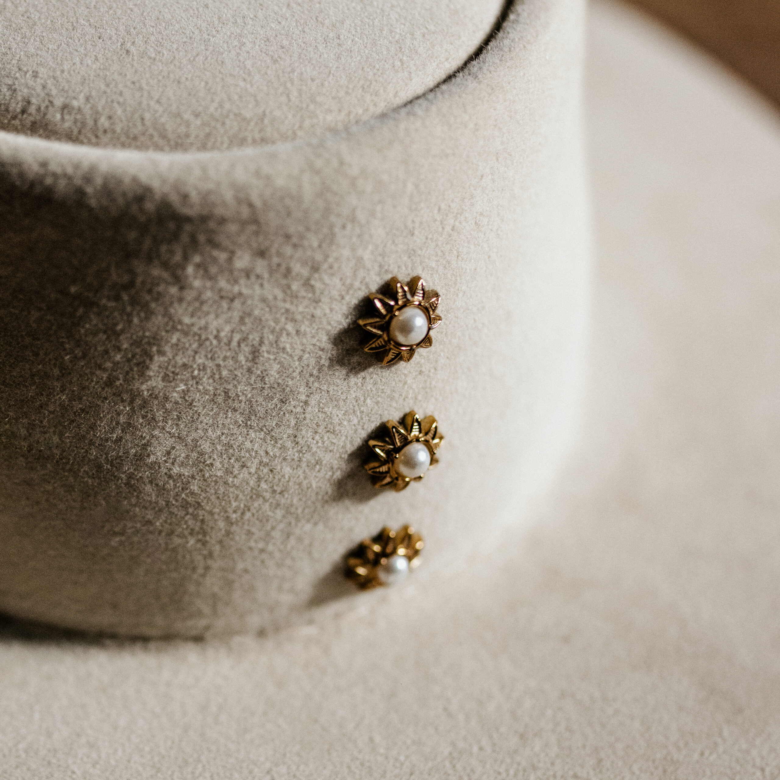 Crown of the Vagabond hat on Mallorca in color Bone Oasis-shaped. Centred golden pearl rivets and a clean flat 8cm / 3.14in brim.