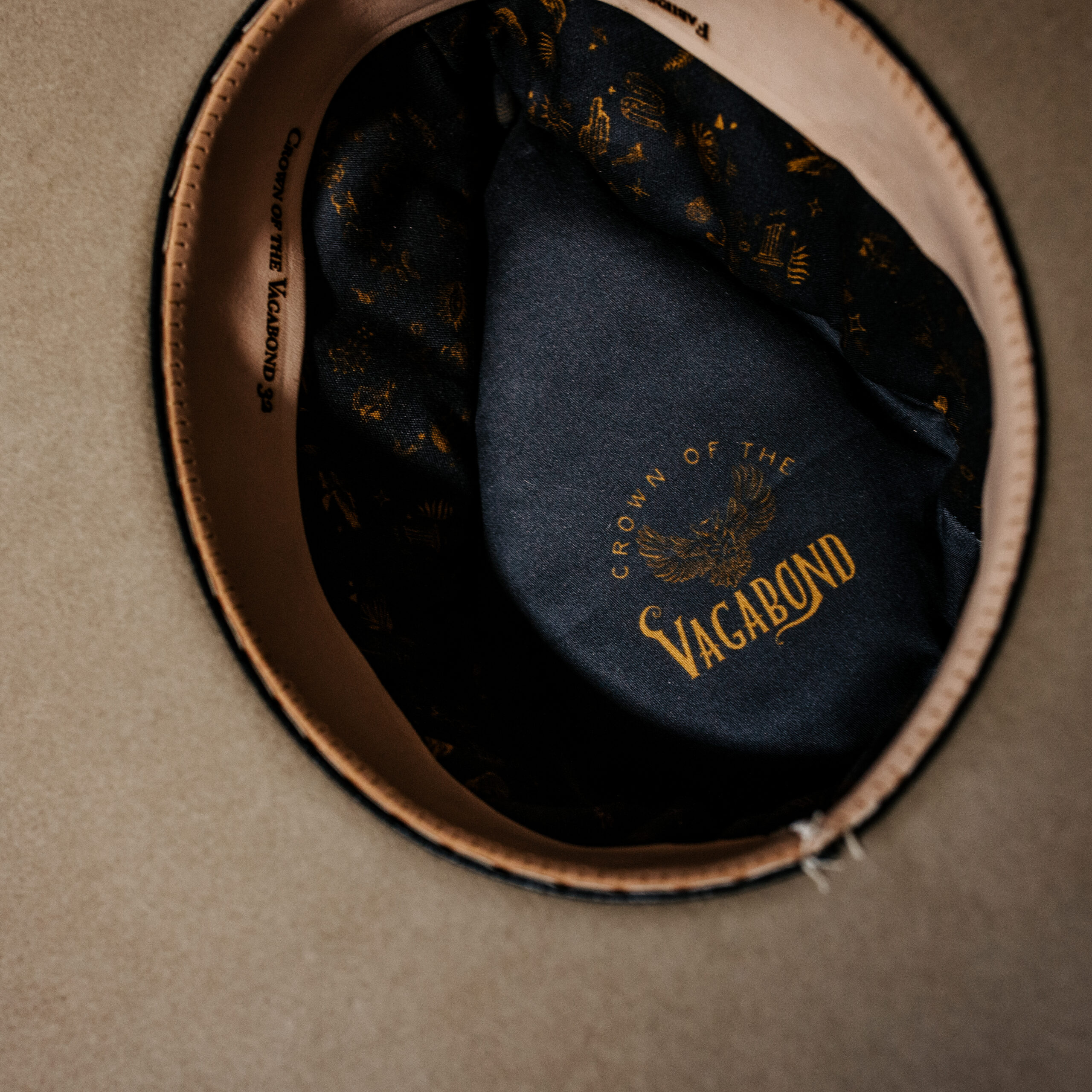 Crown of the Vagabond hat on Mallorca in color Prairie Dust Gold-Digger-shaped. Off centred golden coins and pearls on leather strand.